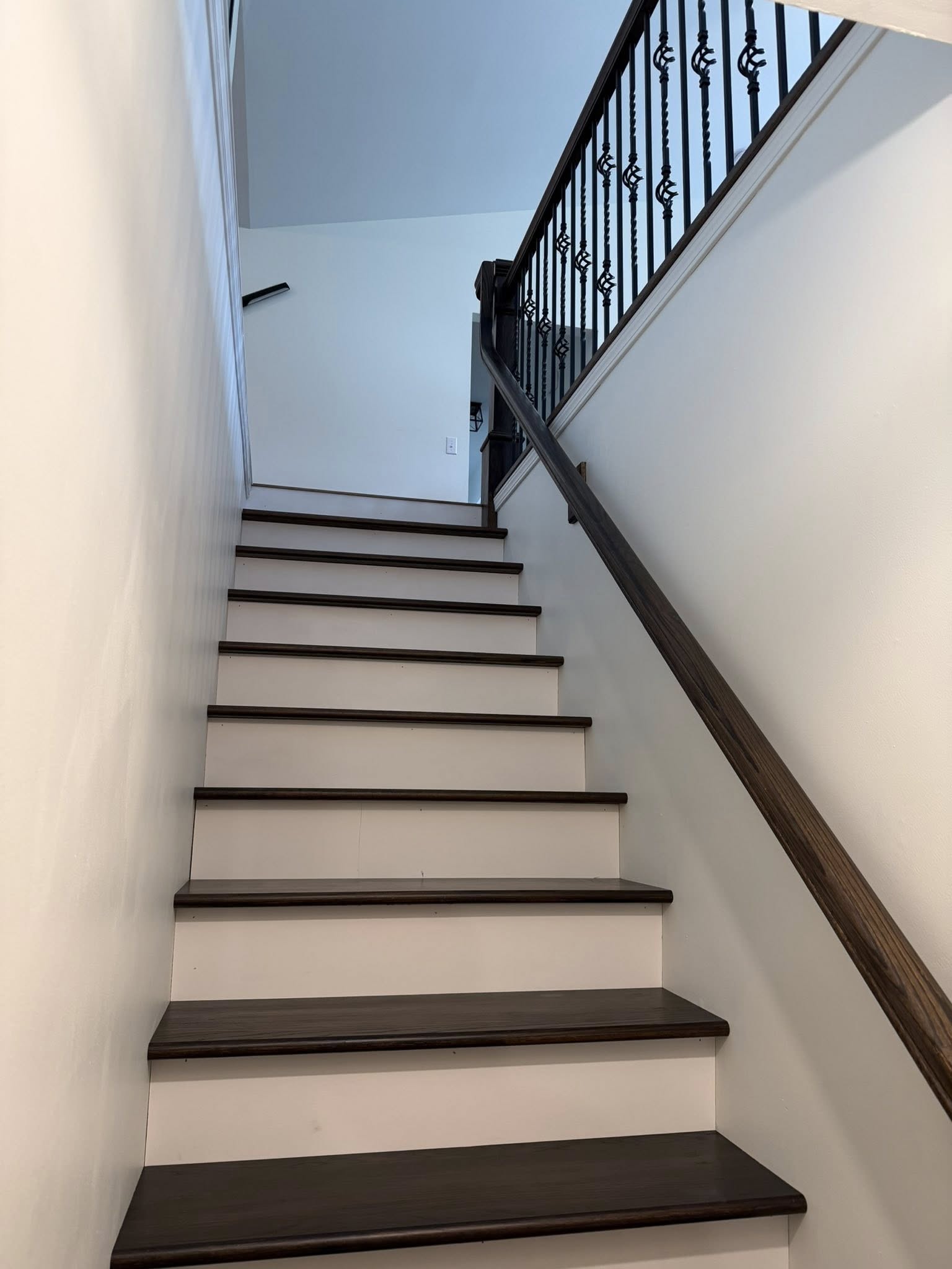 Custom oak staircase with new treads, risers, thicker newel post, and metal balusters