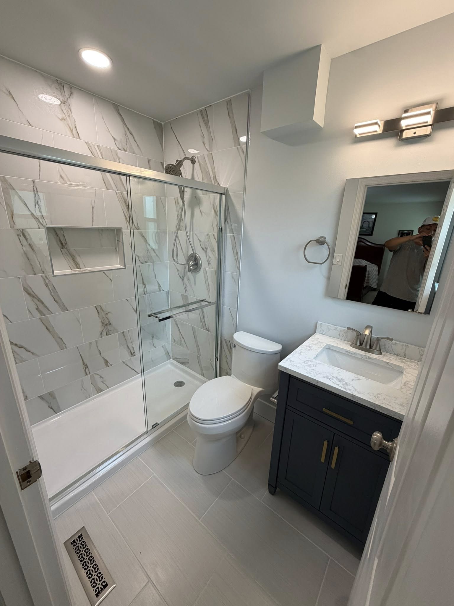 Bathroom after full gut renovation, with new tile, recessed medicine cabinet niche, and proper roof-vented exhaust