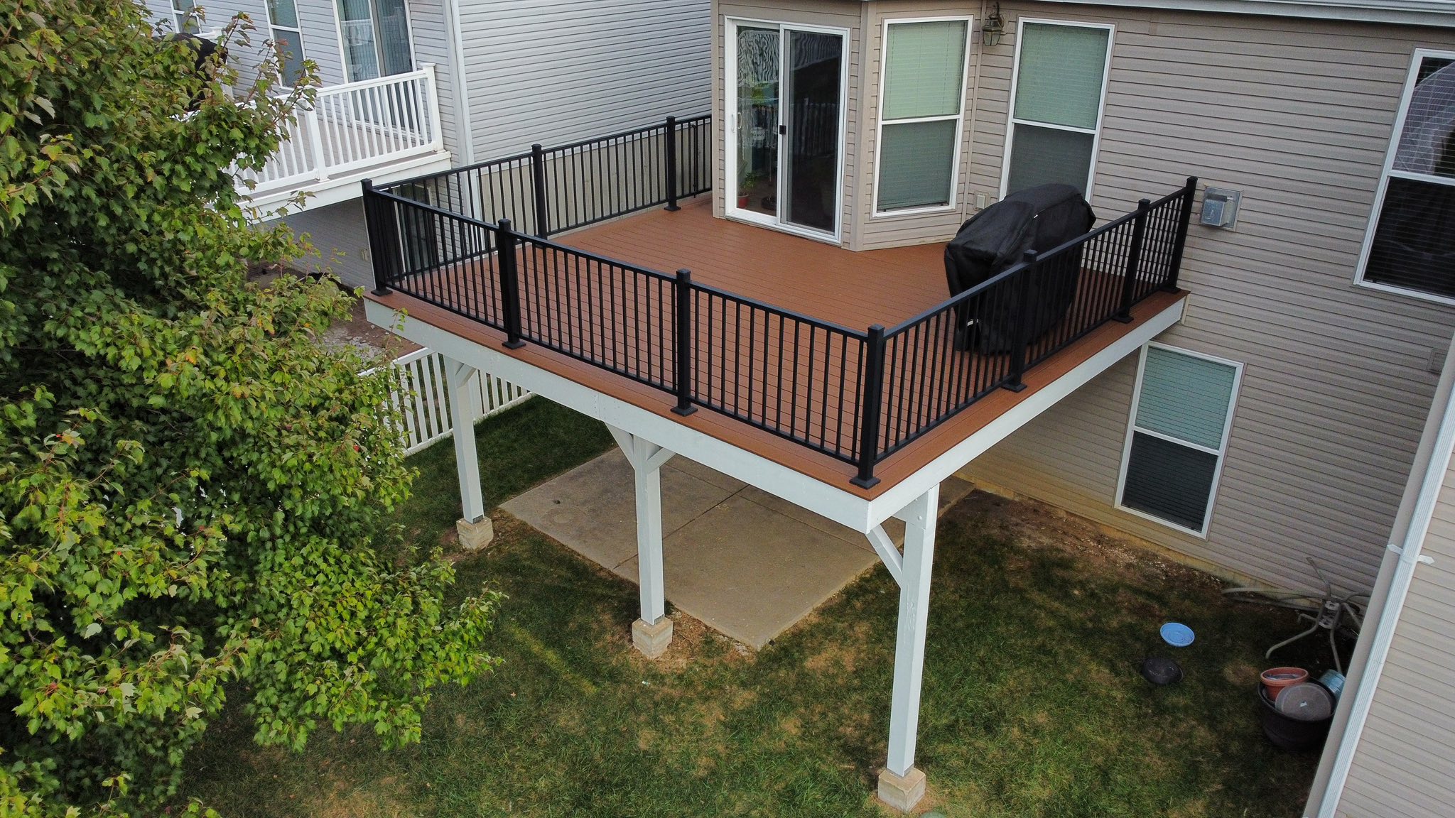 Second-story composite deck with aluminum rails and white lattice skirting, built by Howe Renovations in O'Fallon MO