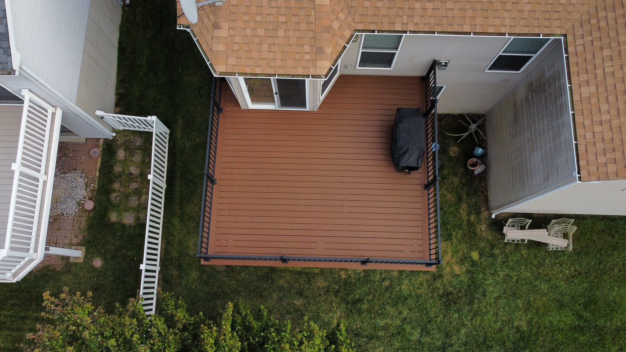 Composite deck with extended footprint and aluminum rails, viewed from the yard